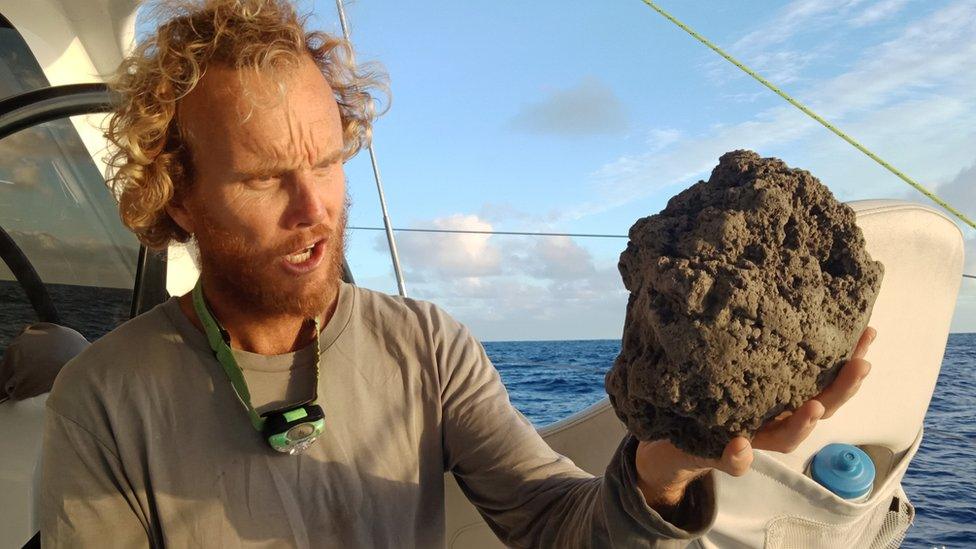 Michael Hoult holds a large pumice stone the size of his head