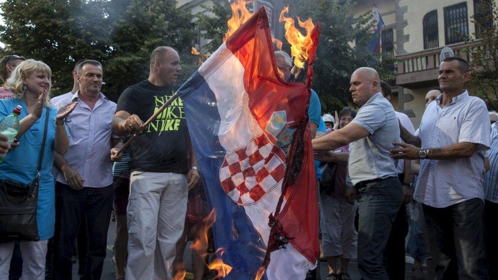 Serbian nationalist leader Vojislav Seselj (C behind the flag) and his party members burn Croatian national flag, 5 Aug