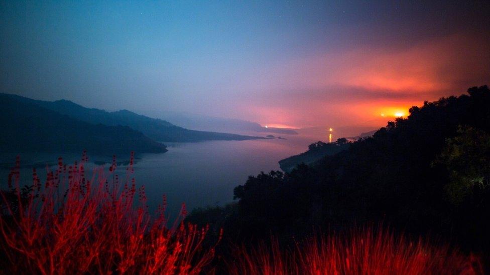 The Thomas Fire burns a hillside behind Lake Casitas in Ventura, California on 8 December 2017