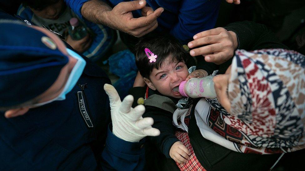 A Syrian child cries as her mother argues with a Hungarian policeman about being allowed to board a train leaving for the Austrian border at the Keleti railway station on 10 September 2015 in Budapest, Hungary