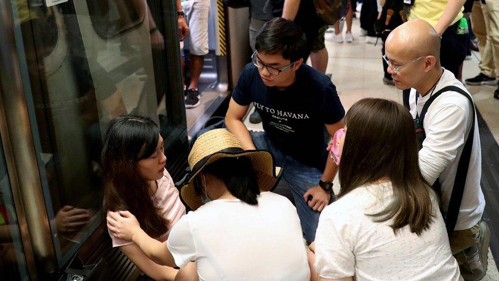 People look after a passenger after she fainted