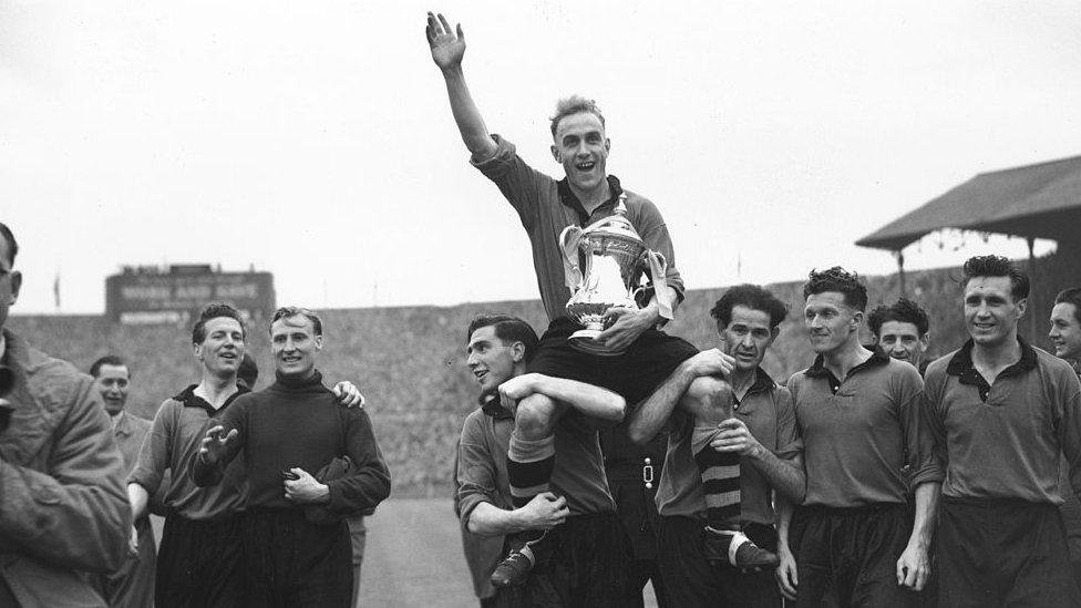 30th April 1949: Wolverhampton Wanderers captain, Billy Wright, and the FA Cup trophy are held aloft by the Wolves team after their 3-1 victory over Leicester City in the FA Cup final at Wembley.