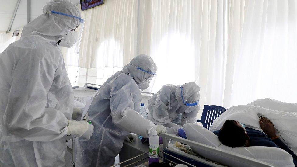 People in PPE treating a patient