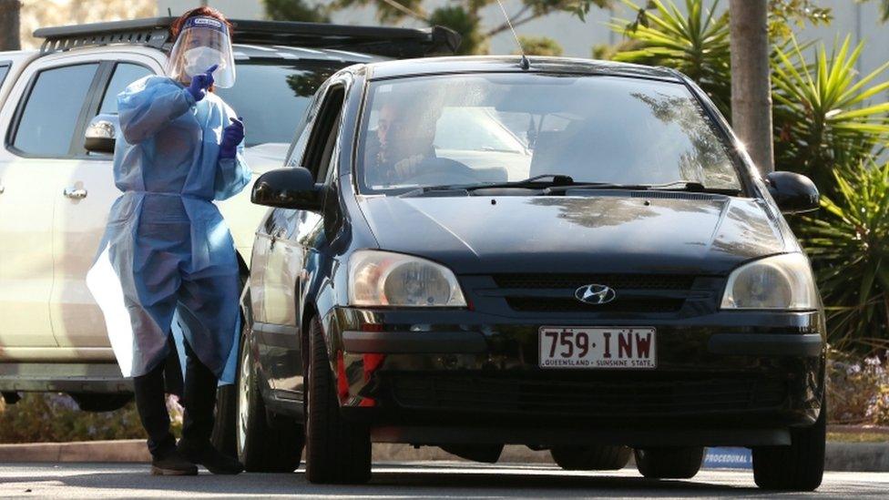 A health worker at a drive-through testing centre in Brisbane