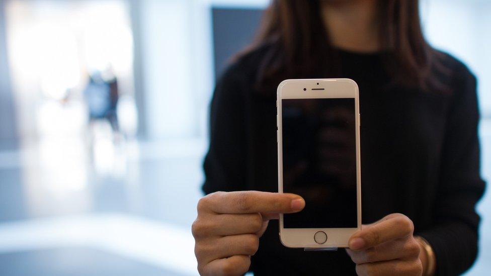 Woman holding an Apple iPhone