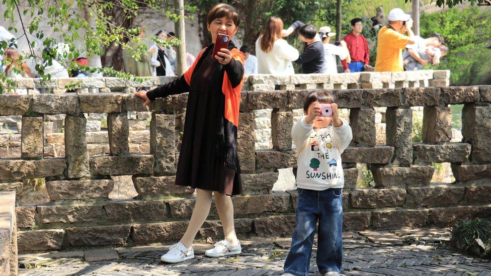 Woman and child pose for selfies