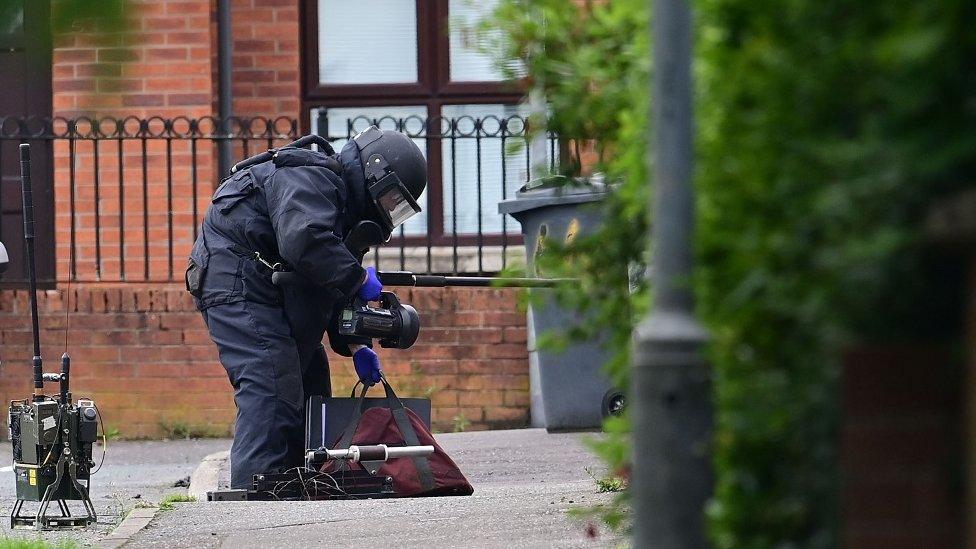 Officer examining object west belfast security alert