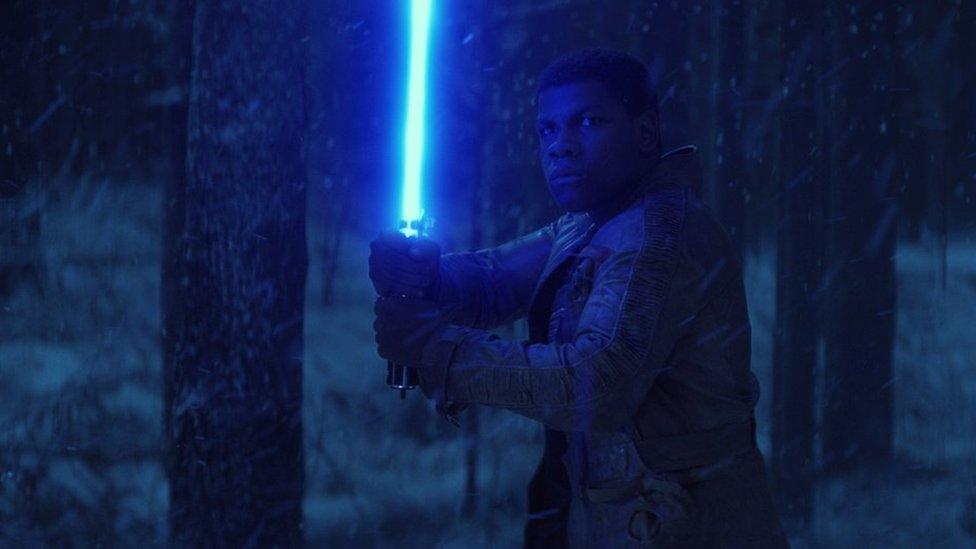 Finn, played by John Boyega weilds a lightsaber