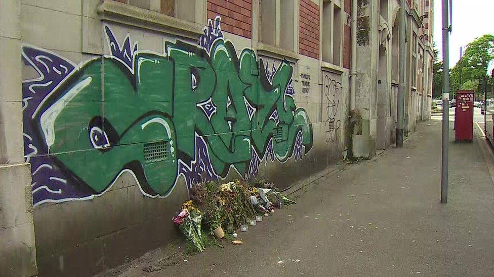 Flowers left in tribute underneath some of Frankie Morris' graffiti artwork