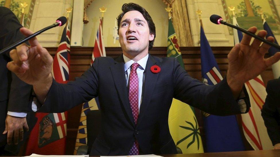 Justin Trudeau holds two microphones