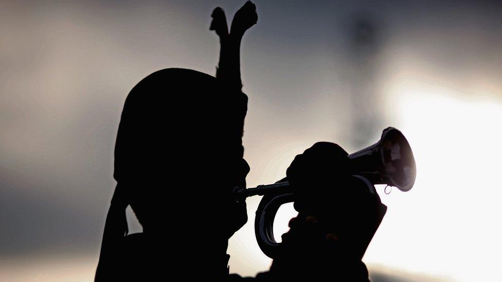 A bugler plays at George Square, as people gathered to pay tribute to those who lost their lives during conflicts on November 11, 2009