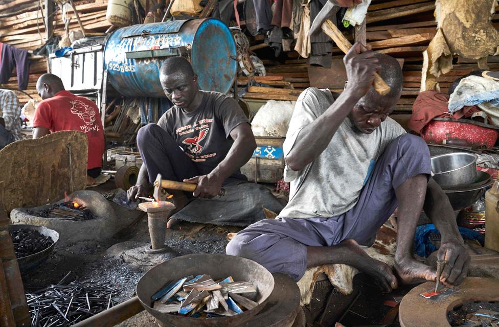 Blacksmiths are seen at work preparing parts to be used to build boats at the port of Mopti on October 13, 2018. - Due to the strategic position close to the Niger River, fishing represents one of the Mopti"s most important activity