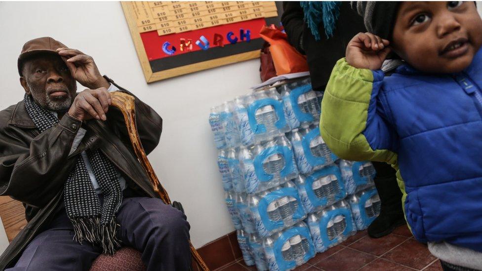 Henry Lindsey 82 and Mychal Adams, 1, sit outside Heavenly Host Baptist Church