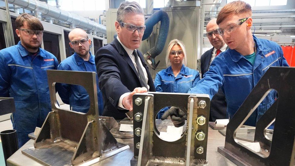 Sir Keir Starmer talking to workers while looking at metalwork at BAE Systems in Barrow-in-Furness, Cumbria