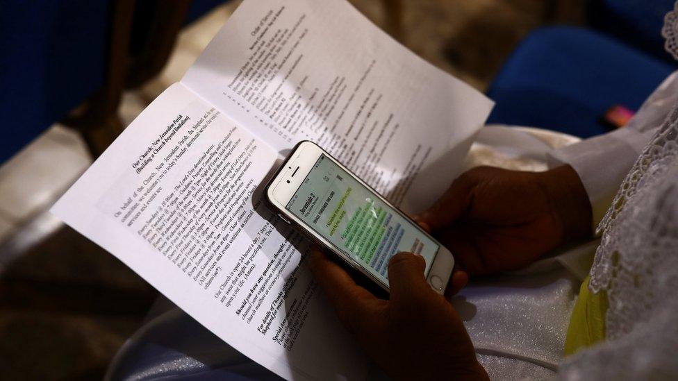 A worshipper reads a passage from the Bible on her smartphone during a Sunday service