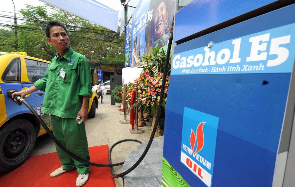 An employee of a local PetroVietnam filling station pumps locally made ethanol-blended gasoline into a taxi cab in Hanoi on 15 September 2008.