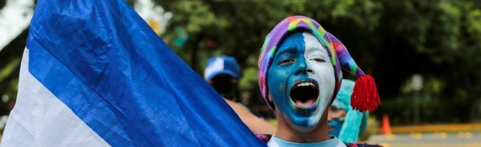 A demonstrator holds a national flag during a protest against Nicaraguan President Daniel Ortega"s government at Central American University (UCA) in Managua, Nicaragua July 1, 2019