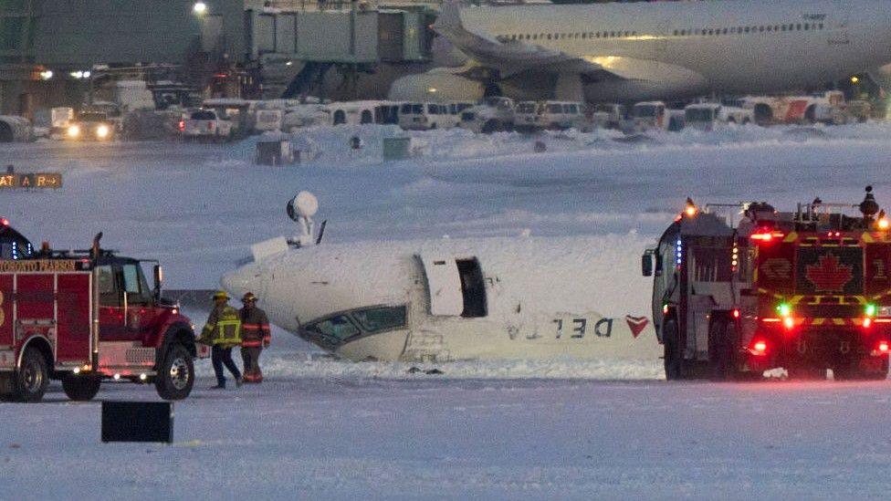 An upside-down plane on the airport tarmac at Toronto Pearson airport