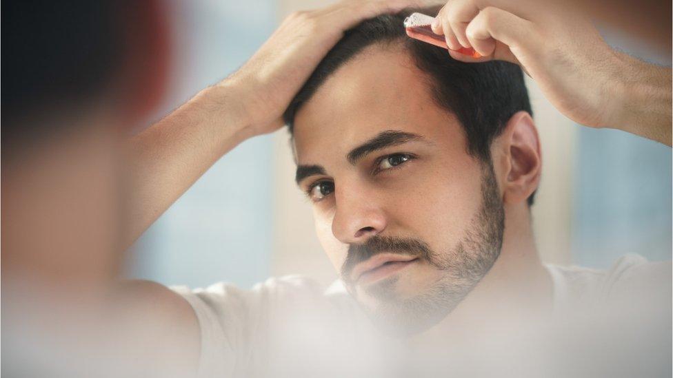 Young man checking his hairline