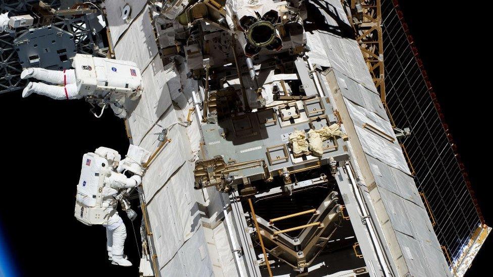 Astronauts fixing ISS