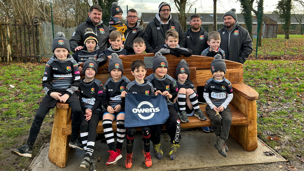 Young rugby players on the Phil Bennett memorial bench