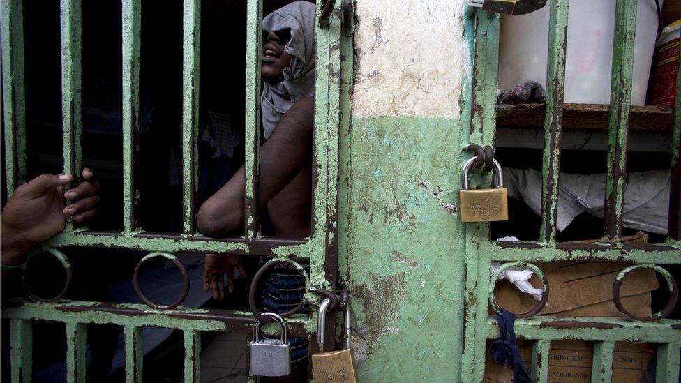 An ailing prisoner stands in a cell designated for sick prisoners near the infirmary in the National Penitentiary in downtown Port-au-Prince