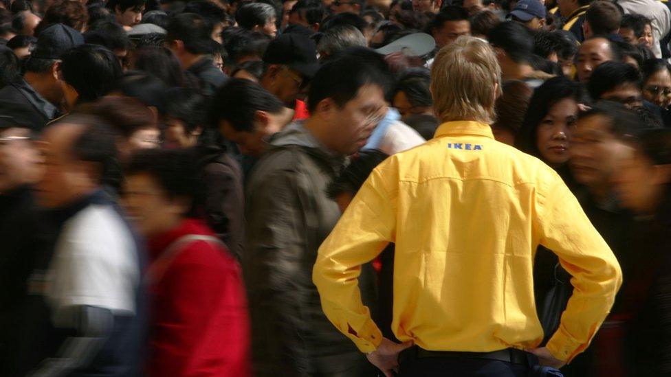 Customers wait in line to visit Ikea's new store in Beijing, China