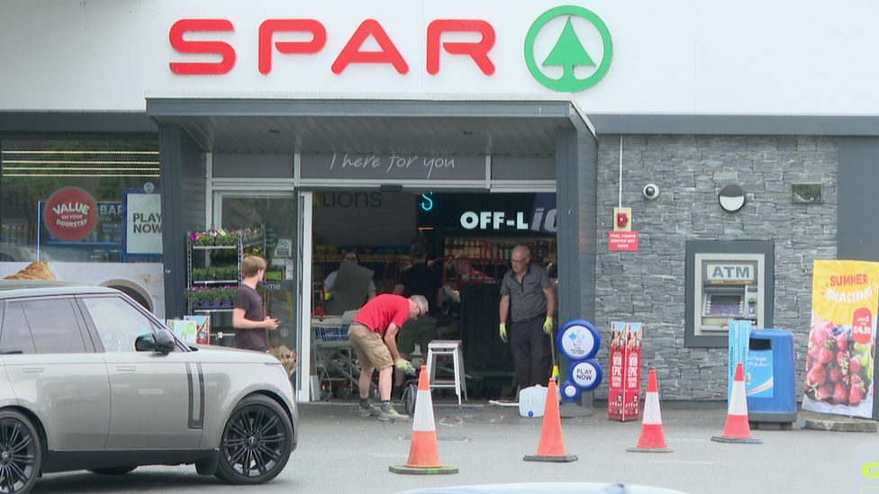 Men repairing shop entrance