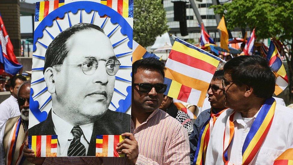 A man holds a large poster of Dr BR Ambedkar during in Canada