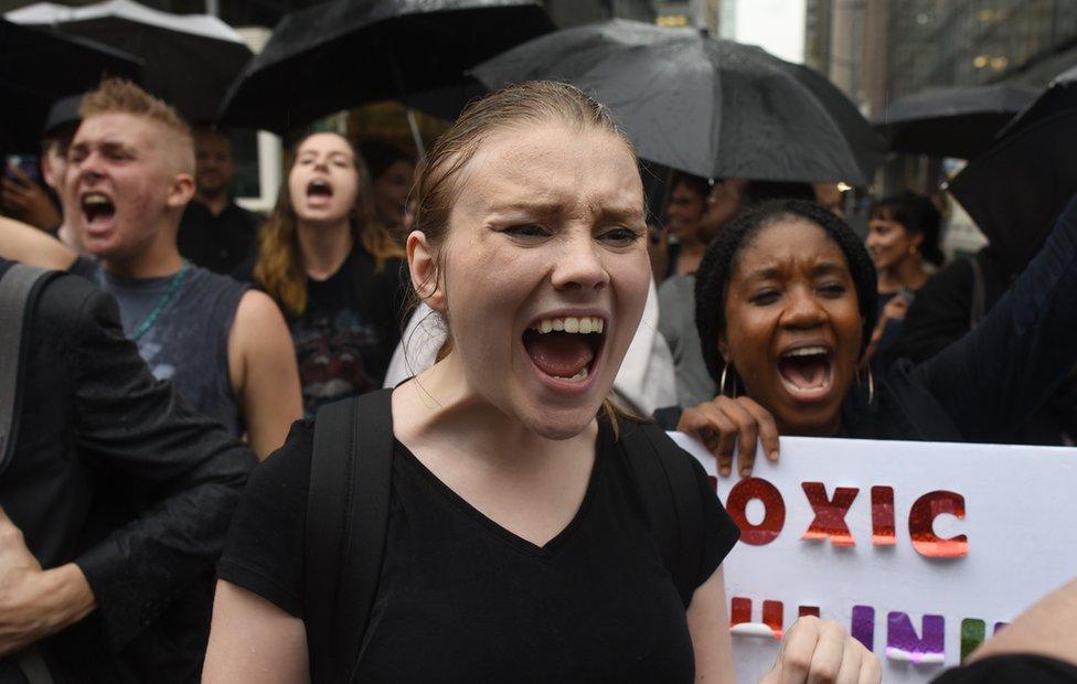 Women shout and hold placards