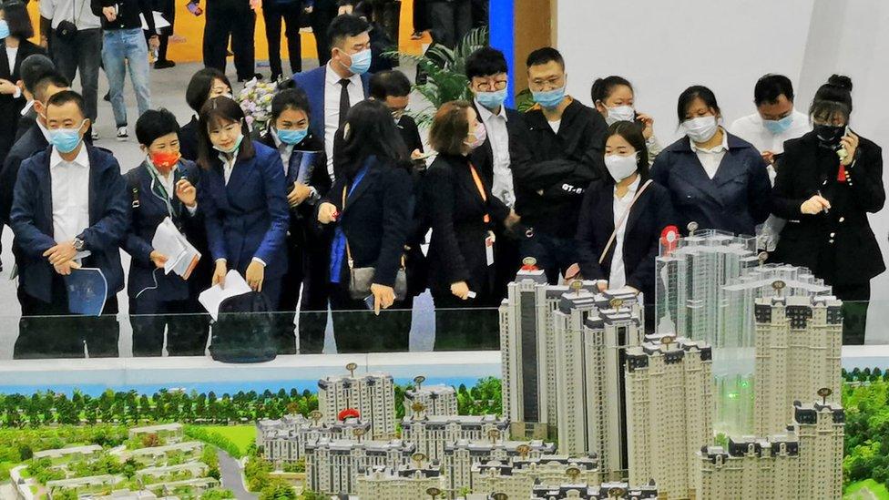 People look at models of houses at the 2021 Dalian autumn real estate fair at Dalian World Expo Centre.