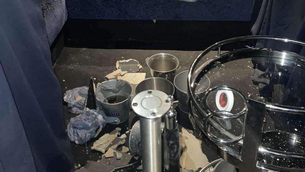 Buckets placed on the floor of one of the strip clubs. They appear to be being used to catch leaking water. Wet tissues surround the buckets along with debris.