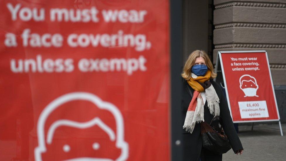 Woman walking past a sign