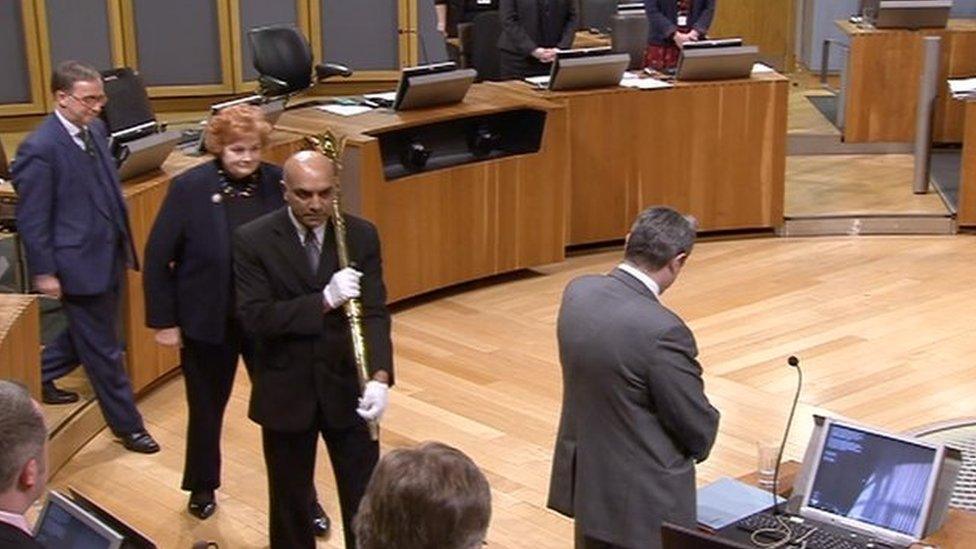 The ceremonial mace being carried out