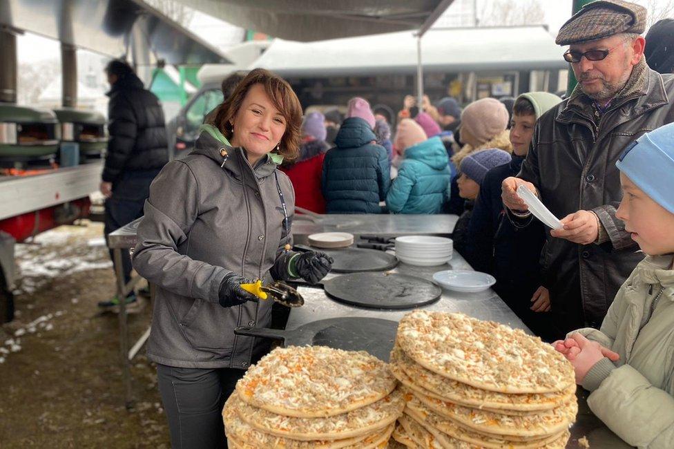 A woman serving pizza