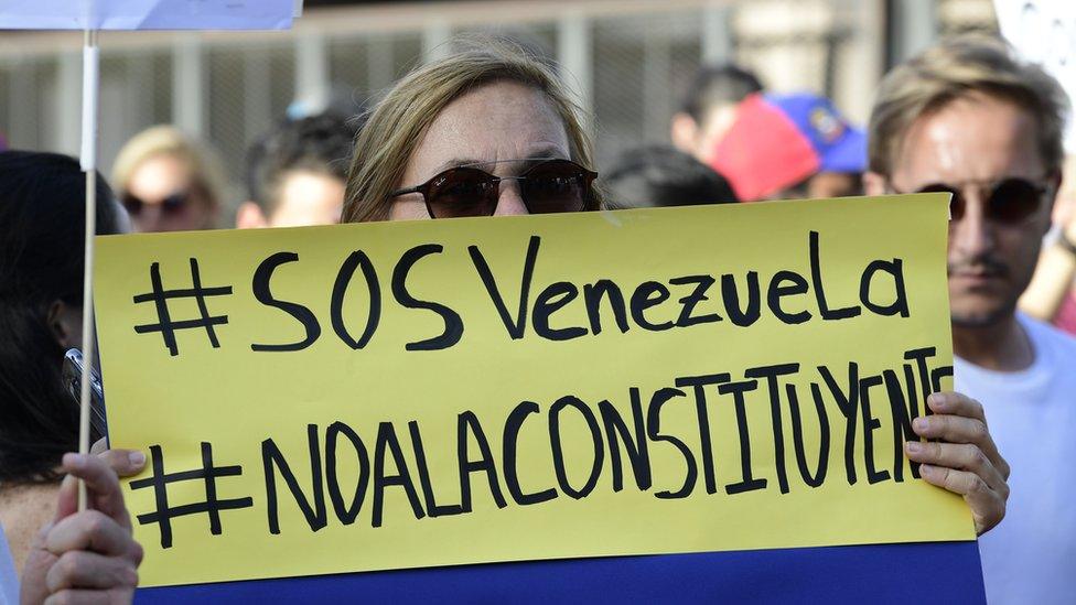 A Venezuelan holds up a placard during a protest on July 30, 2017 against Venezuelan President Nicolas Maduro and the election of a Constituent Assembly