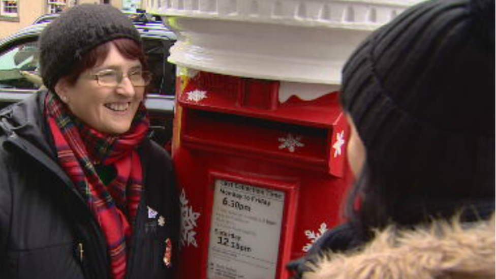 A woman listening to the post-box