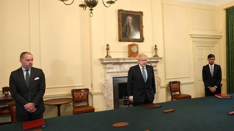 Cabinet Secretary Mark Sedwill, Prime minister Boris Johnson and Chancellor of the Exchequer Rishi Sunak stand inside 10 Downing Street, London, to observe a minutes silence in tribute to the NHS staff