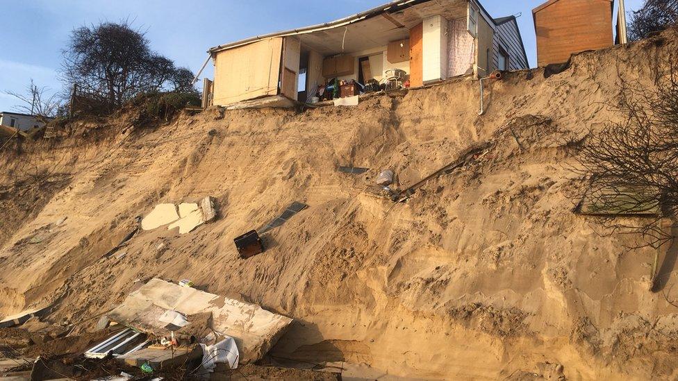 Partially-collapsed house at Hemsby, with debris strewn beneath