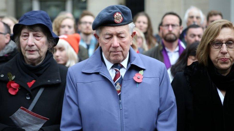 Members of the public look on as they observe a two minute silence in London