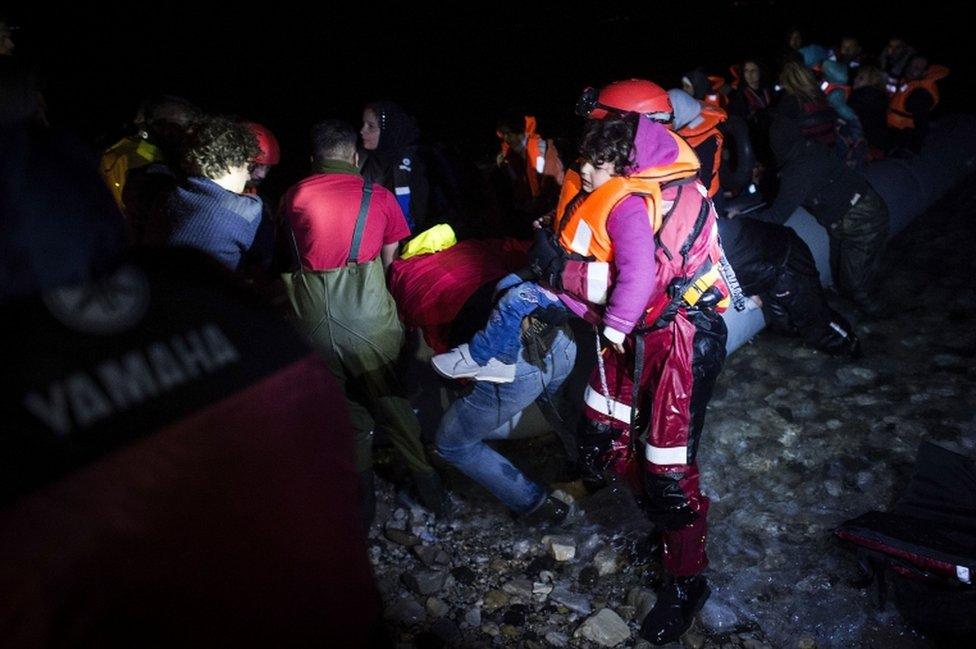 A small Syrian girl is being helped shortly after arriving on an inflatable boat with other refugees, crossing the sea from Turkey to Lesbos on 9 March 2016