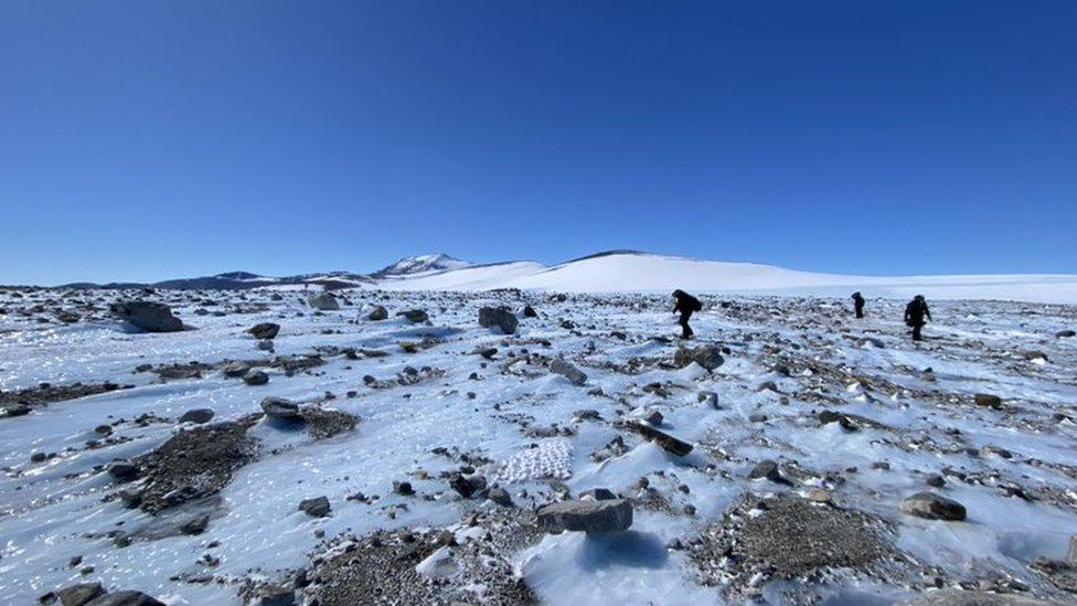 rocky and snowy landscape with people in background