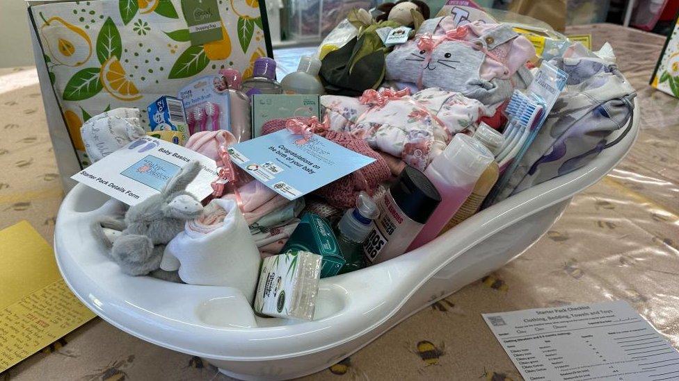 A bath containing toiletries, including shampoo, toothbrushes and clothes