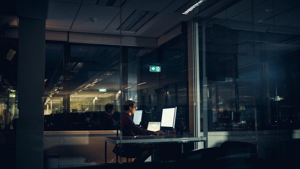 Man works alone in office at night