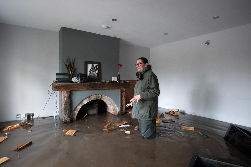 Gabrielle Burns-Smith looks out from her flooded home