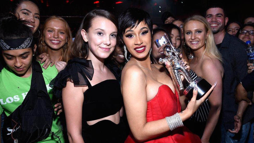 Cardi B stands with Millie Bobby Brown