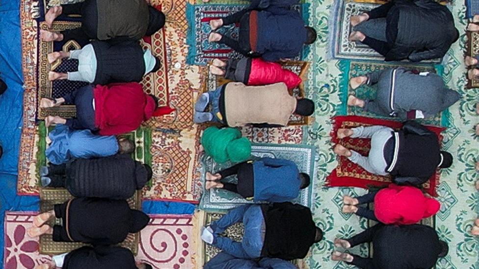 People praying outside of al-Farouk mosque ruins in Rafah on 10 April