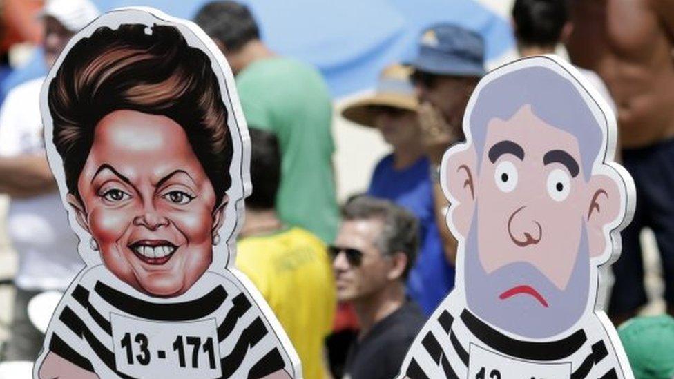 People hold likenesses of former Brazilian president Luiz Inacio Lula da Silva and Brazil's President Dilma Rousseff in prison stripes during a demonstration for the impeachment of Rousseff on Copacabana beach, Rio de Janeiro, Brazil, Sunday, Dec. 13, 2015.