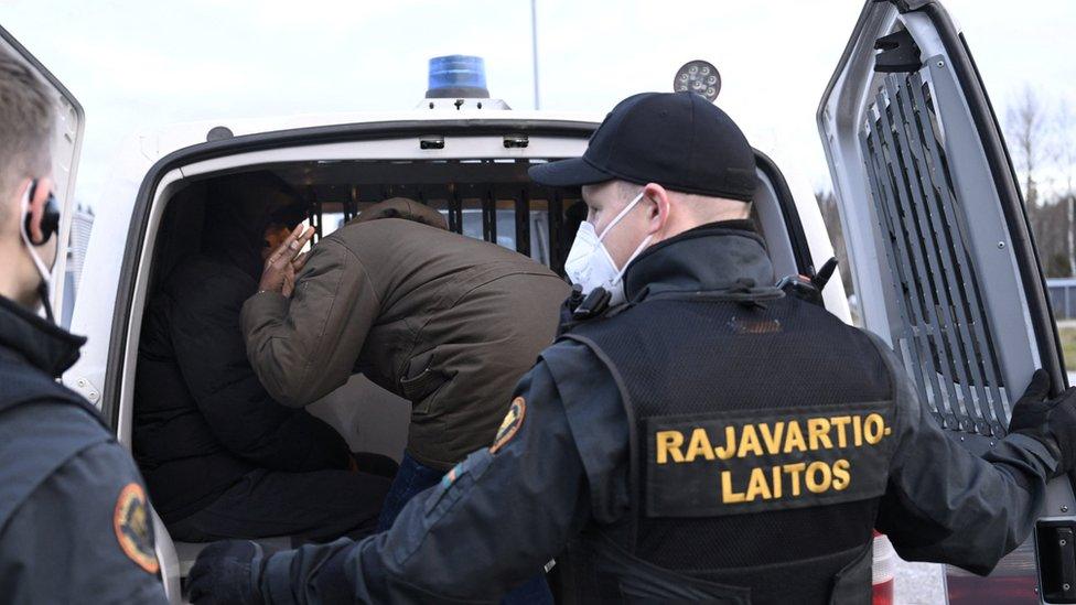 Finnish border guards transport asylum seekers who arrived from Russia on 16 November