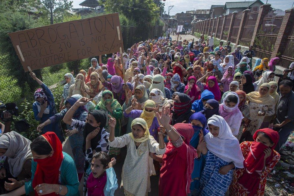 Protesters in Srinagar holding a sign reading: "Abrogation Article 370 is not acceptable for us"